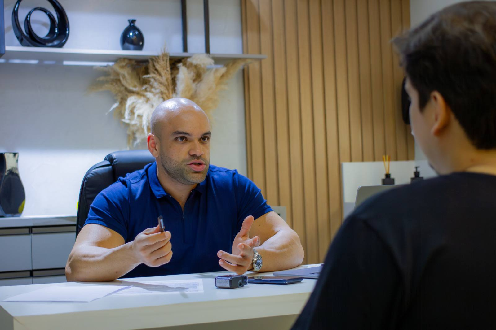 Dr. João Vitor Vaz Ribeiro em consulta com paciente no consultório